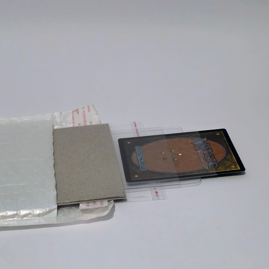 Magic: The Gathering card secured in a semi-rigid holder with cardboard and bubble mailer for safe shipping and grading.