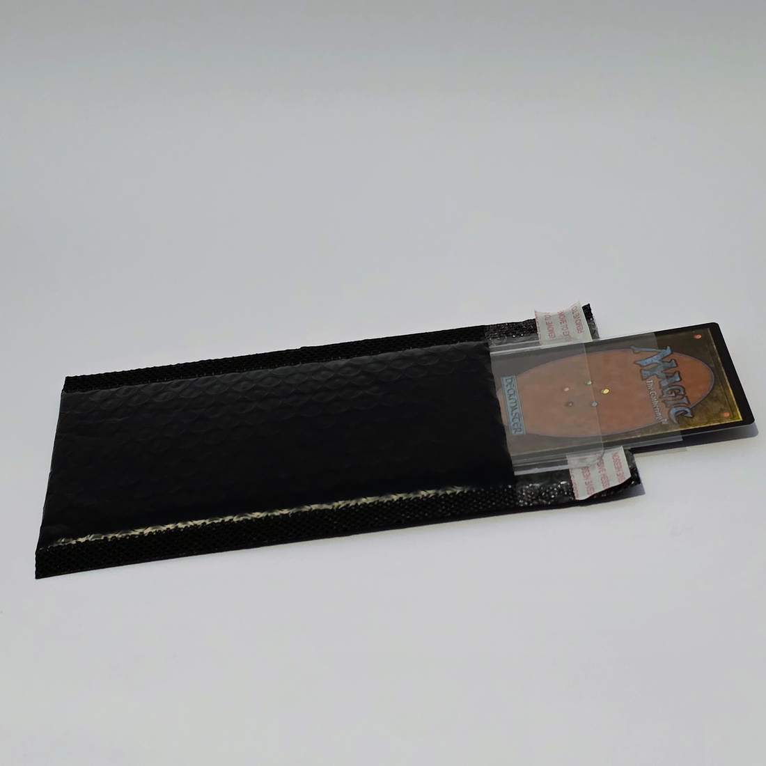 Trading card protected in a semi-rigid sleeve and packed inside a padded bubble mailer for mailing
